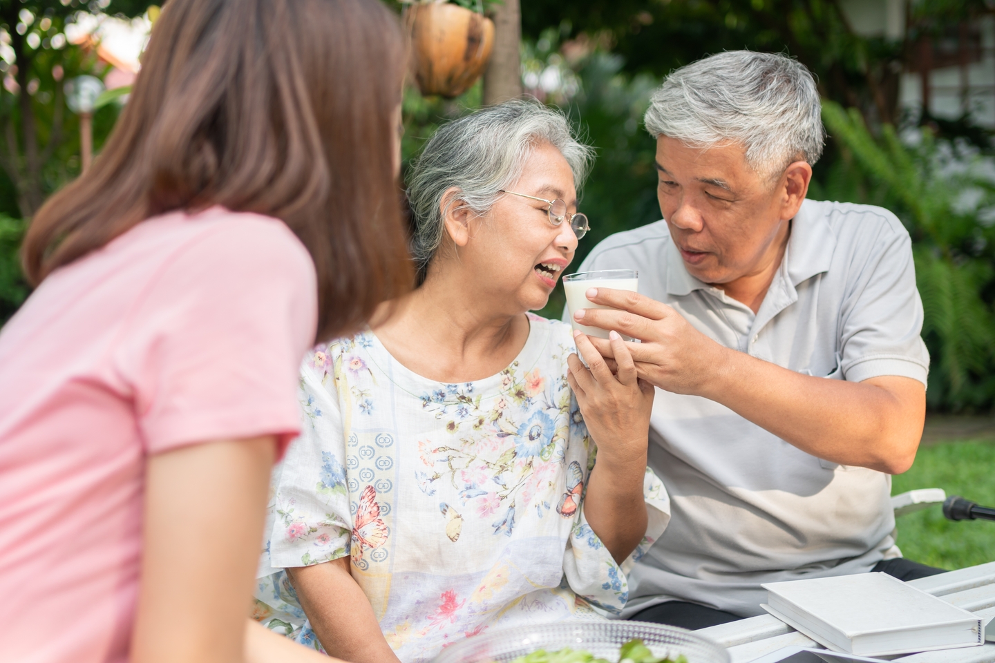 Happy,asian,family,enjoy,lunch,together,in,backyard.,husband,feeding